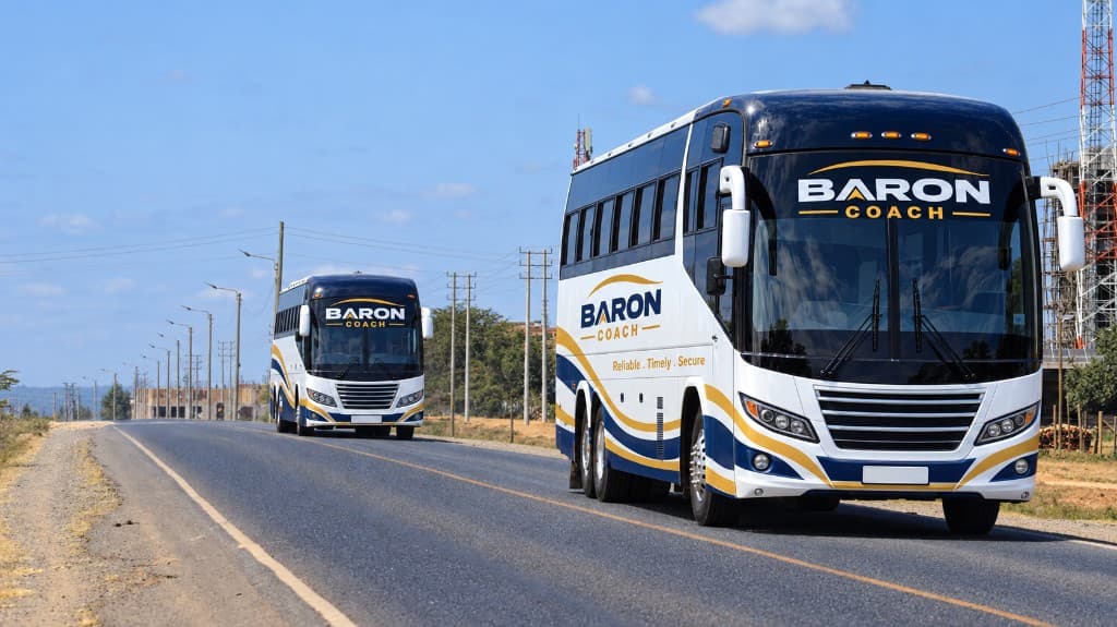Two Baron Coach buses travelling on an open highway.